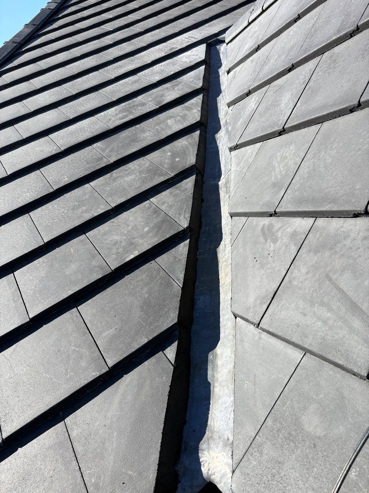 A lead valley between courses of slate on a garage roof