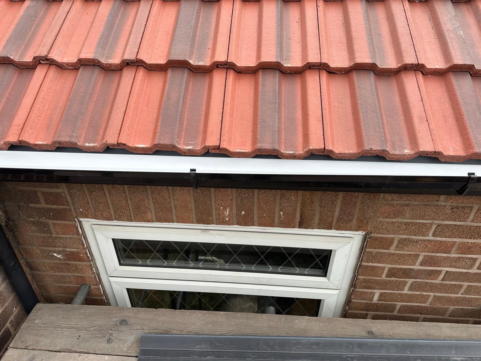 New white fascia and black gutter under red pantiles
